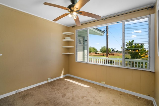 empty room with light colored carpet, a wealth of natural light, crown molding, and ceiling fan