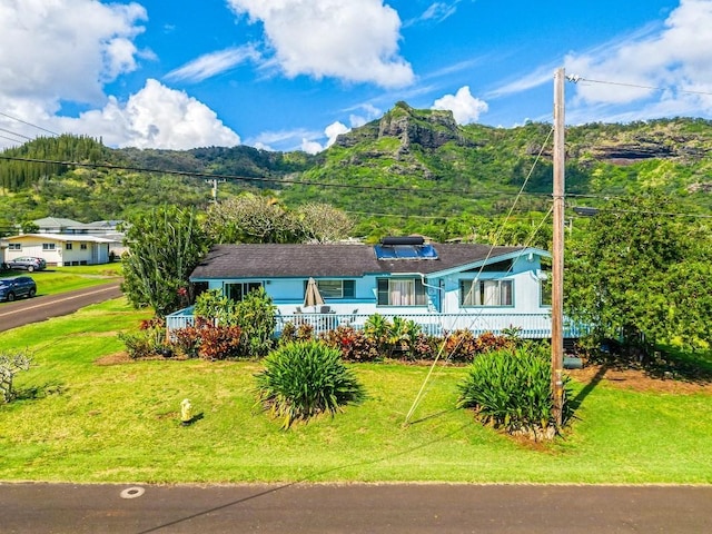 ranch-style house featuring a mountain view and a front lawn