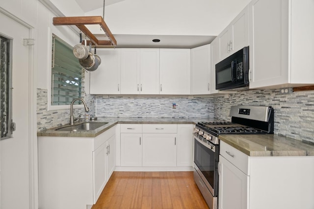 kitchen featuring tasteful backsplash, gas range, sink, light hardwood / wood-style flooring, and white cabinets