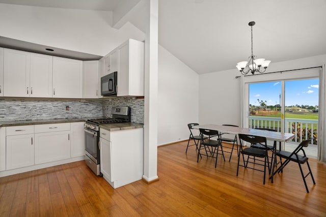 kitchen with white cabinets, a notable chandelier, decorative light fixtures, and stainless steel gas range