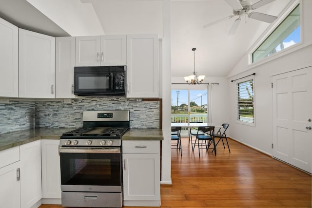 kitchen with gas range, white cabinetry, and vaulted ceiling