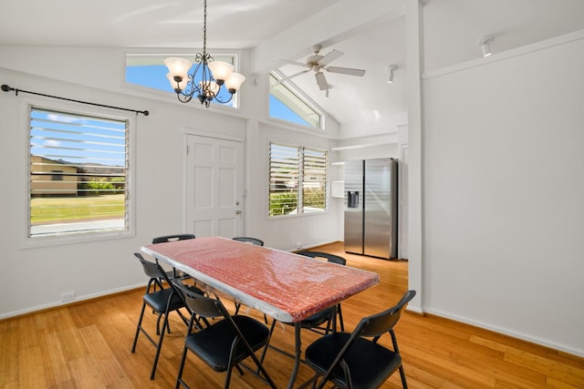 dining room with ceiling fan with notable chandelier, vaulted ceiling with beams, and light hardwood / wood-style floors