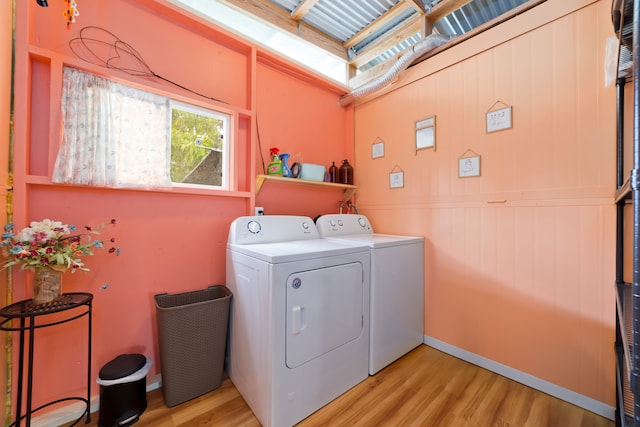 laundry room with light hardwood / wood-style floors and washing machine and clothes dryer