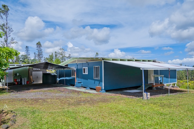 exterior space with a carport and a lawn