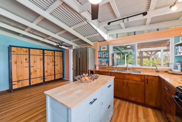 kitchen with a center island, light hardwood / wood-style floors, white cabinetry, and wood counters