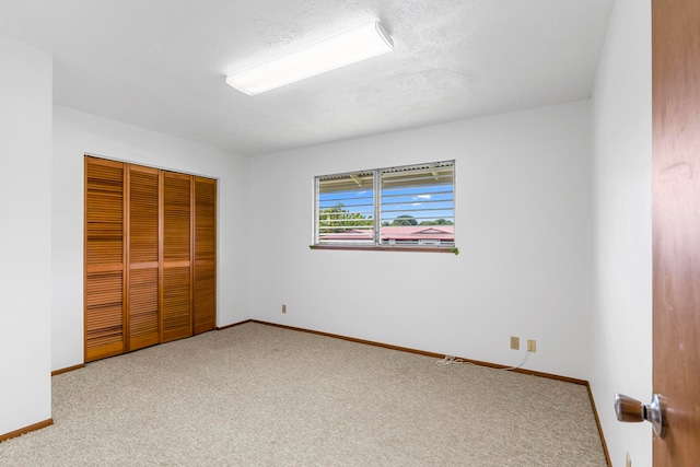 unfurnished bedroom featuring a textured ceiling, a closet, and carpet