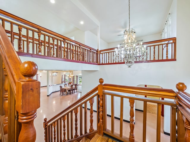 stairs with tile patterned floors and a chandelier