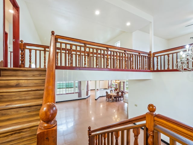 staircase featuring a chandelier and a high ceiling