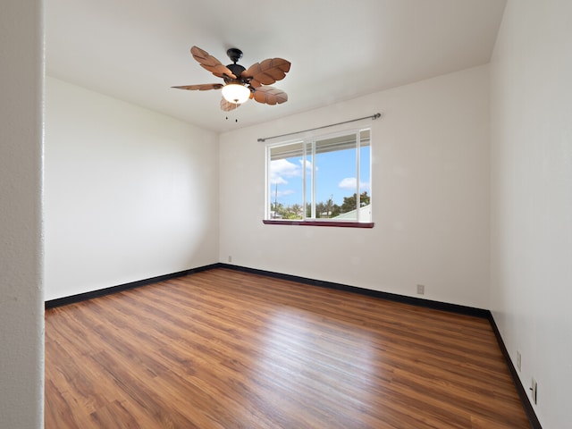 empty room with ceiling fan and dark hardwood / wood-style flooring