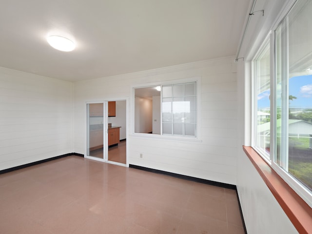 unfurnished room featuring ornamental molding and plenty of natural light