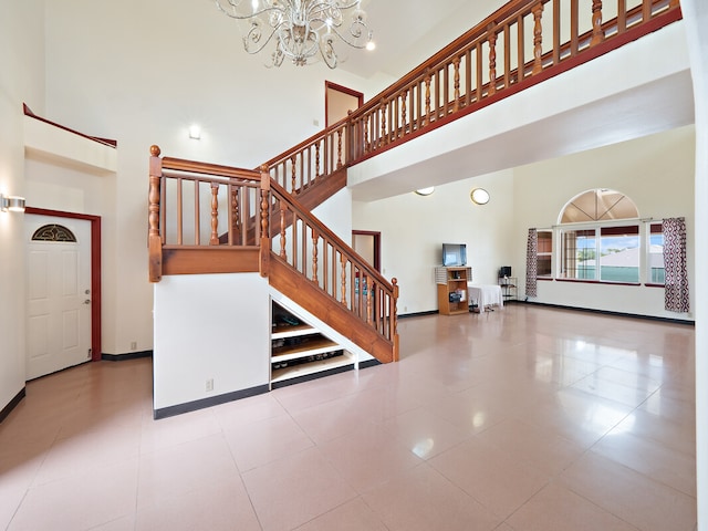 stairs with tile patterned floors, a high ceiling, and an inviting chandelier