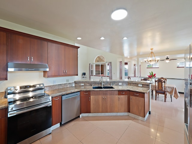 kitchen with appliances with stainless steel finishes, sink, kitchen peninsula, pendant lighting, and light tile patterned floors