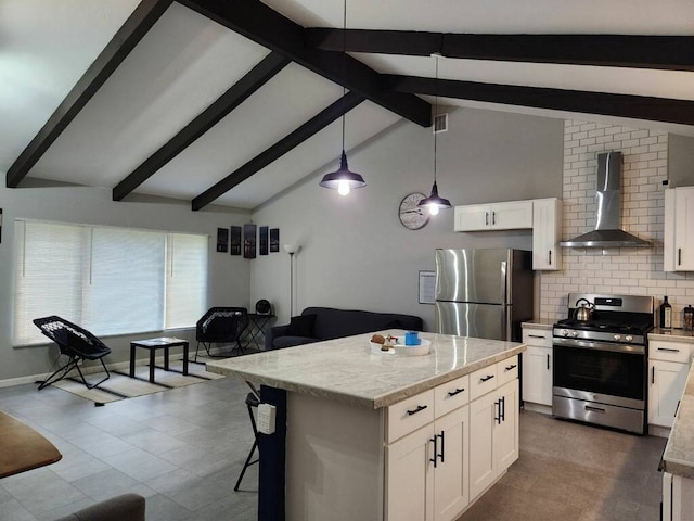 kitchen featuring appliances with stainless steel finishes, wall chimney range hood, decorative light fixtures, and white cabinetry