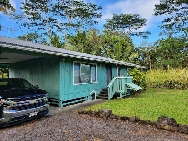 view of front of home with a front lawn and a carport