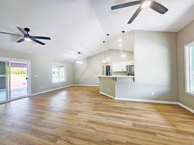 unfurnished living room featuring light wood-style flooring, ceiling fan, and lofted ceiling