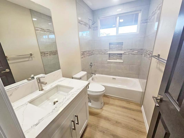 full bathroom with wood finished floors, vanity, baseboards, toilet, and tub / shower combination