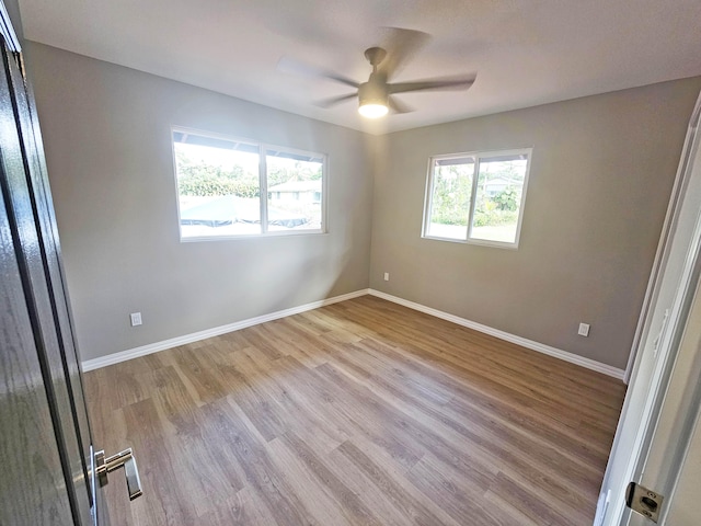spare room with a ceiling fan, baseboards, and wood finished floors