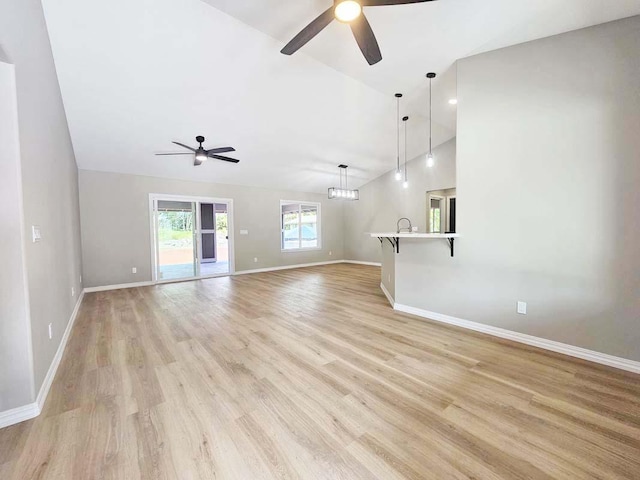 unfurnished living room featuring baseboards, a ceiling fan, and lofted ceiling