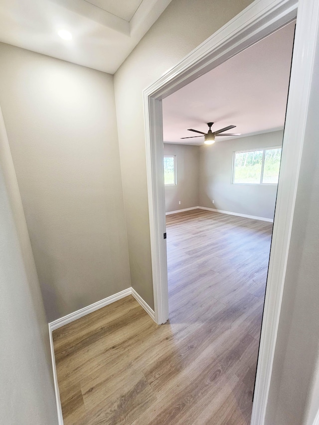 unfurnished room with a ceiling fan, baseboards, plenty of natural light, and wood finished floors
