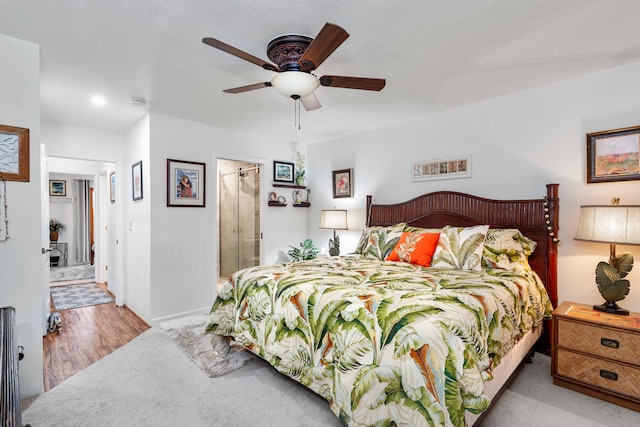 bedroom featuring connected bathroom, light hardwood / wood-style flooring, and ceiling fan