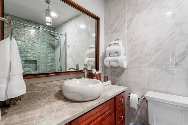 bathroom with vanity, an enclosed shower, toilet, and tile walls