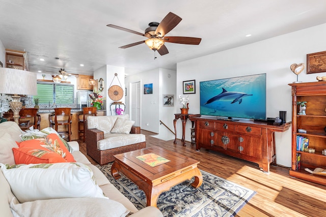 living room with ceiling fan and light hardwood / wood-style flooring