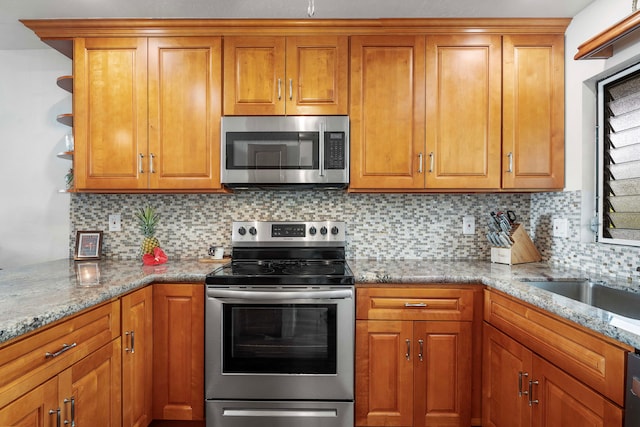 kitchen with light stone countertops, tasteful backsplash, and appliances with stainless steel finishes