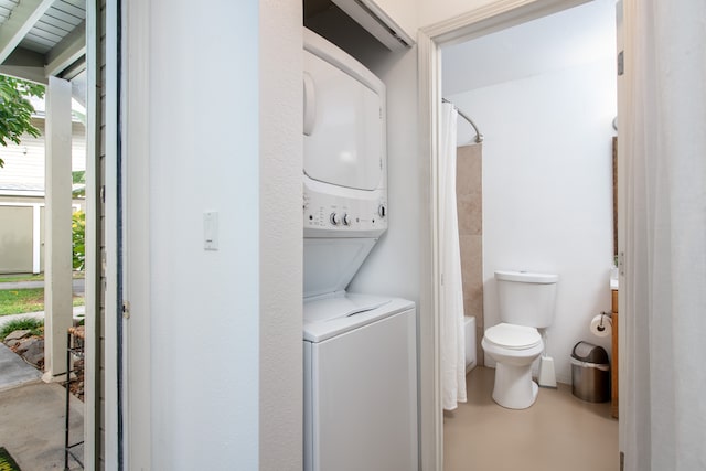 laundry area featuring stacked washer / drying machine