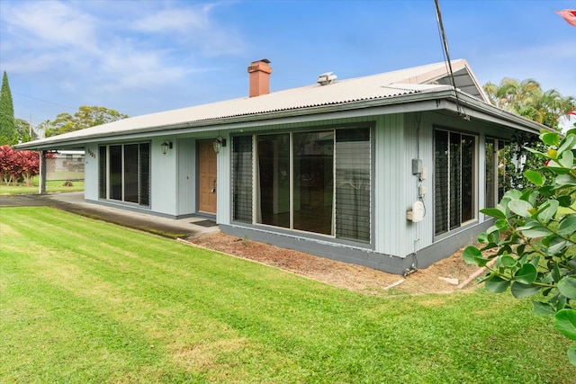 rear view of house featuring a lawn