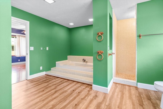 bathroom featuring hardwood / wood-style floors, toilet, and a bathtub