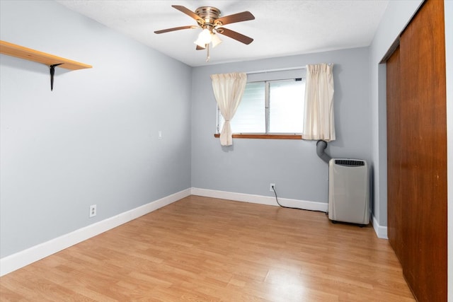 unfurnished bedroom with ceiling fan, a closet, and light wood-type flooring