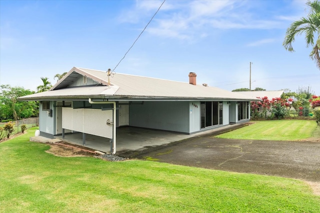 back of house with a carport and a lawn