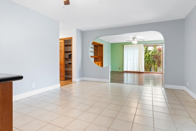 tiled spare room with ceiling fan