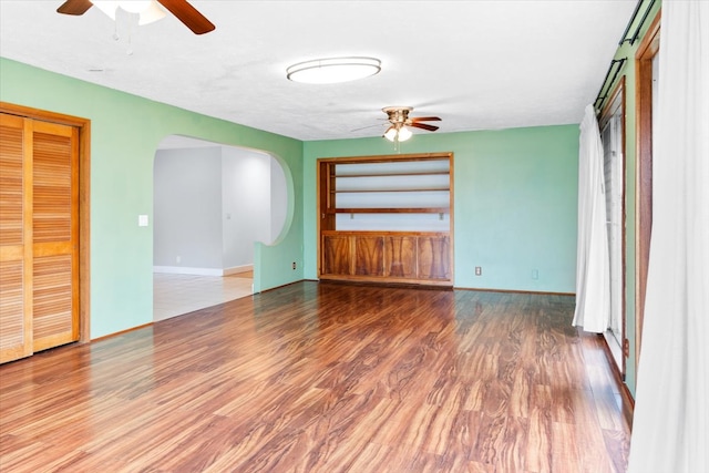 unfurnished living room with hardwood / wood-style flooring and ceiling fan