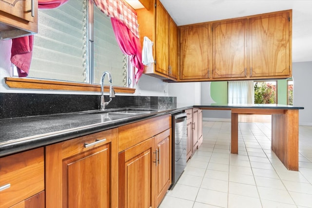 kitchen featuring light tile patterned floors, dark stone countertops, and sink