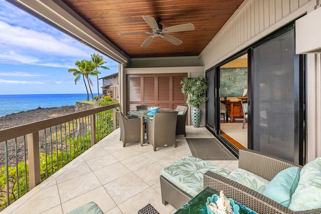 balcony featuring a water view, ceiling fan, and a patio