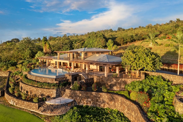 back of property with a swimming pool with hot tub and a patio area