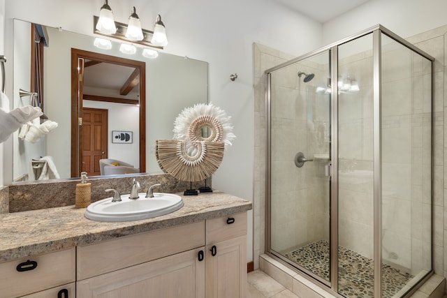 bathroom with vanity and a shower with door