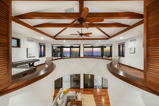 interior space with lofted ceiling with beams and hardwood / wood-style flooring