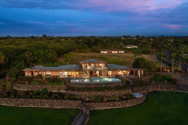 back house at dusk featuring a patio