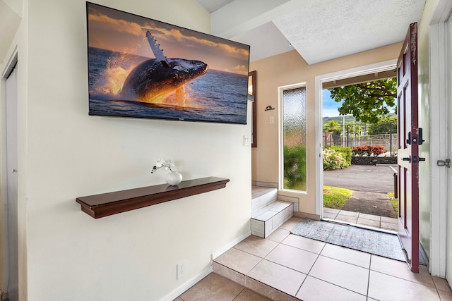 tiled entrance foyer with a textured ceiling and plenty of natural light