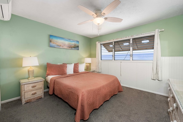 carpeted bedroom with ceiling fan, a textured ceiling, and a wall mounted air conditioner