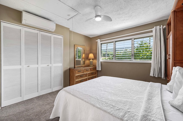 bedroom featuring ceiling fan, a closet, an AC wall unit, carpet, and a textured ceiling