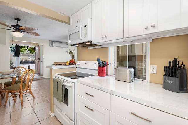 kitchen featuring white cabinets, light stone countertops, light tile patterned floors, and white appliances