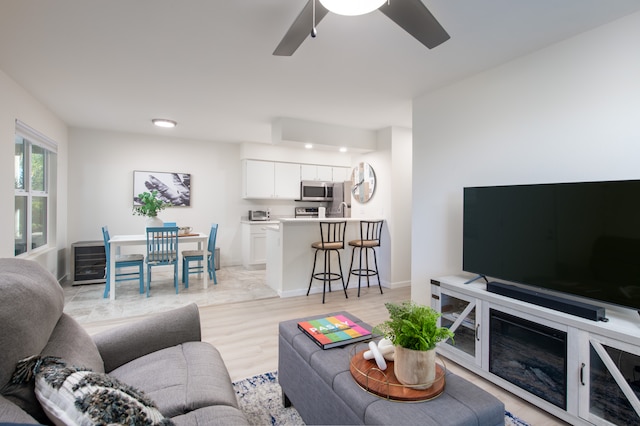 living room featuring ceiling fan and light hardwood / wood-style flooring