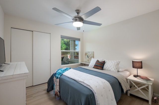 bedroom with a closet, light hardwood / wood-style floors, and ceiling fan