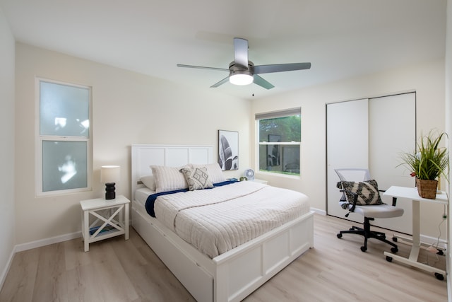 bedroom with ceiling fan, a closet, and light hardwood / wood-style floors