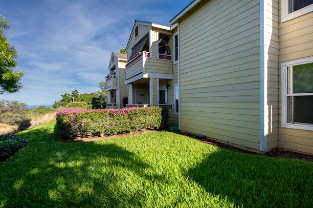 view of property exterior featuring a yard and a balcony