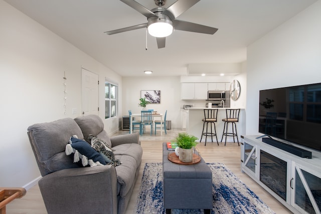 living room with light wood-type flooring and ceiling fan