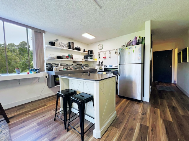 kitchen with dark hardwood / wood-style flooring, white cabinetry, appliances with stainless steel finishes, and a textured ceiling